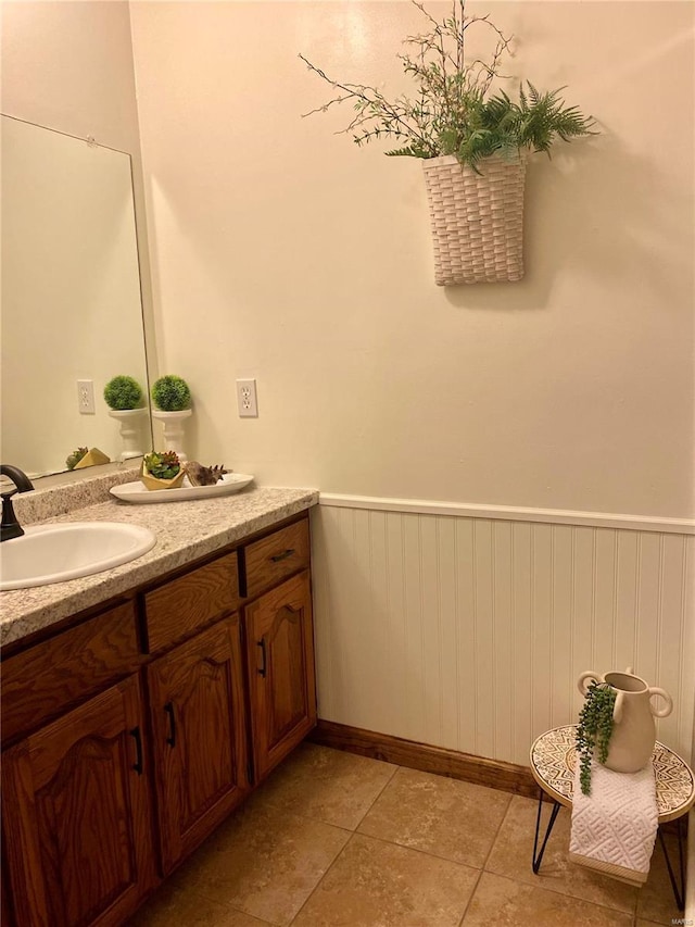 bathroom with vanity, baseboards, and a wainscoted wall