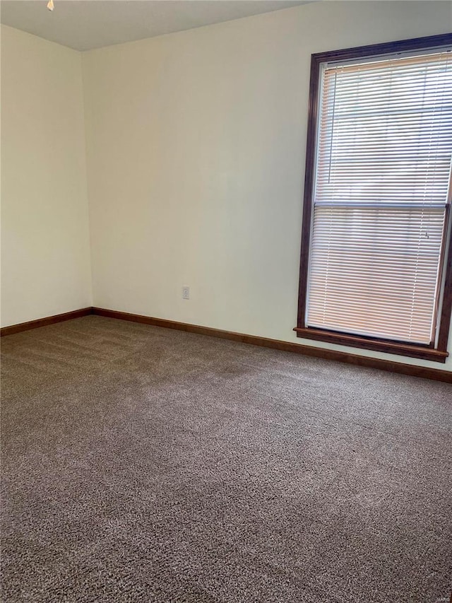 carpeted spare room with baseboards