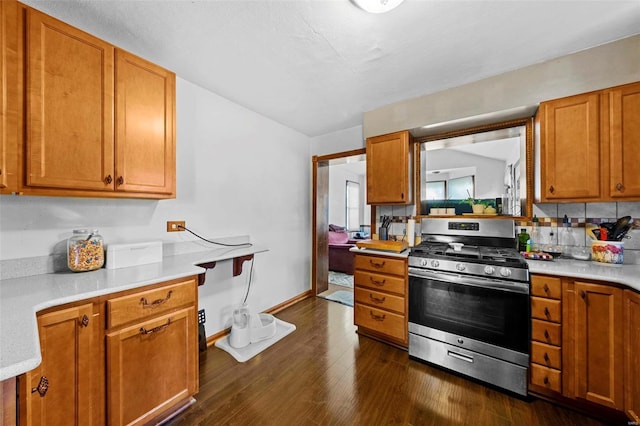 kitchen featuring light countertops, dark wood-type flooring, brown cabinets, and gas range