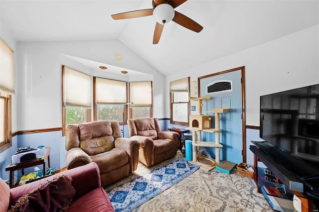 living area with a ceiling fan and lofted ceiling