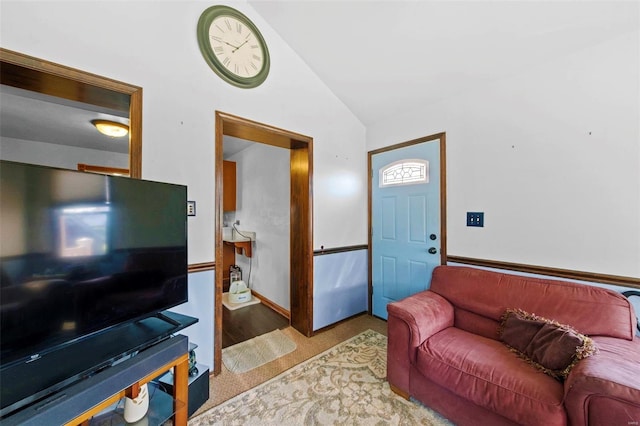 living room featuring carpet floors, baseboards, and vaulted ceiling