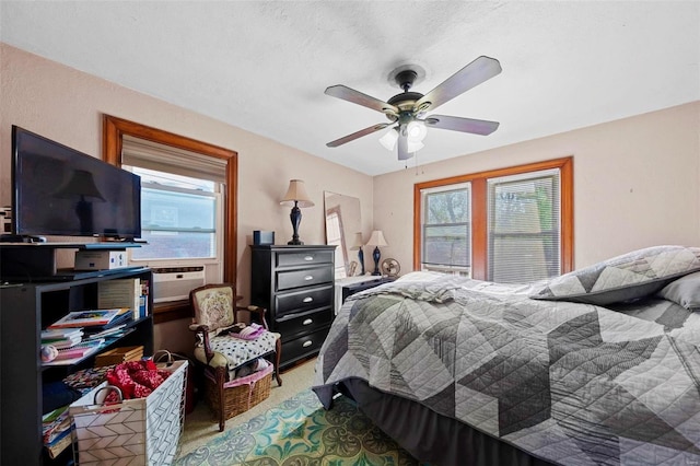 carpeted bedroom with ceiling fan, multiple windows, and cooling unit
