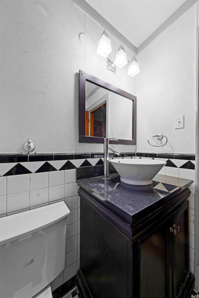 bathroom featuring wainscoting, tile walls, vanity, and toilet
