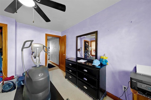 exercise room with baseboards and a ceiling fan