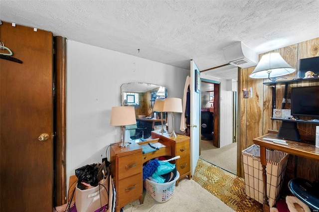 carpeted office featuring wooden walls, a textured ceiling, and visible vents