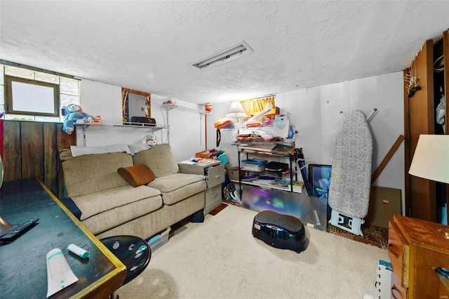 carpeted living area featuring a textured ceiling and visible vents