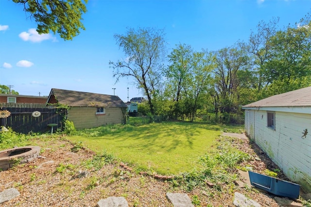 view of yard featuring fence and an outdoor fire pit