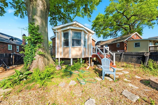 rear view of house with a fenced backyard, stairs, and a wooden deck