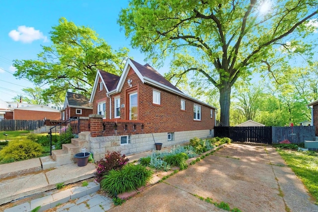 view of side of home with brick siding and fence