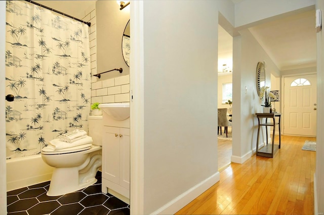 bathroom featuring vanity, hardwood / wood-style floors, shower / bath combo, and toilet