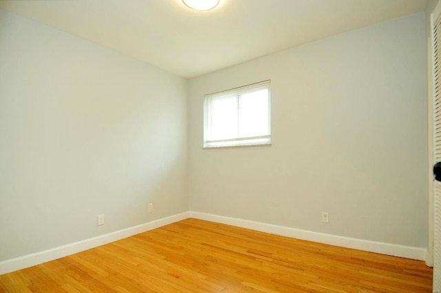 empty room with baseboards and light wood-style flooring