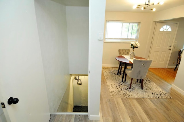 dining area with baseboards, an inviting chandelier, and wood finished floors