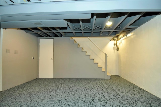 finished below grade area featuring stairway and carpet