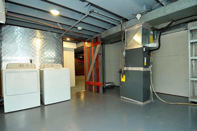 unfinished basement with washer and clothes dryer and heating unit