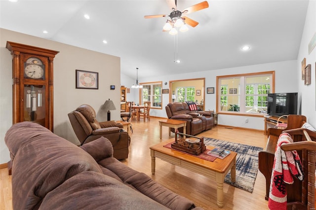 living room with lofted ceiling, light wood-style floors, recessed lighting, and ceiling fan with notable chandelier