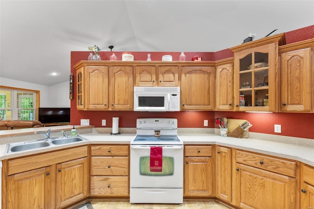 kitchen with light countertops, glass insert cabinets, a sink, and white appliances