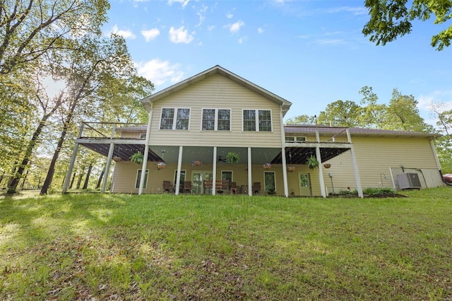 rear view of property with a lawn, central air condition unit, and a deck