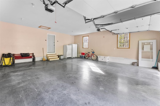 garage with freestanding refrigerator and a garage door opener