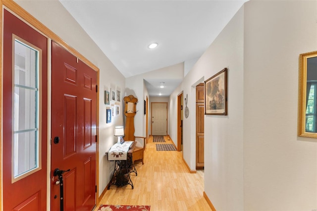 hallway featuring light wood-type flooring, baseboards, lofted ceiling, and recessed lighting