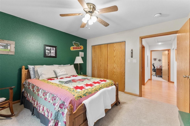 carpeted bedroom with a closet, baseboards, and a ceiling fan