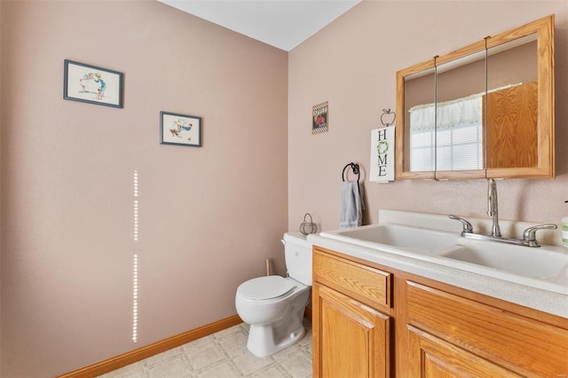 half bath featuring vanity, toilet, baseboards, and tile patterned floors