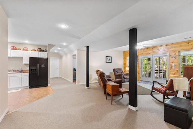 living area with baseboards, wood walls, recessed lighting, and light colored carpet