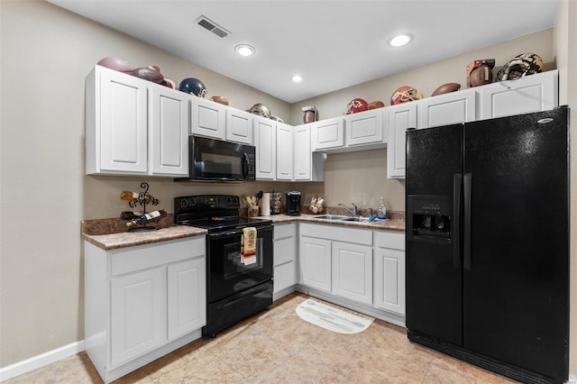 kitchen featuring a sink, black appliances, visible vents, white cabinetry, and light countertops