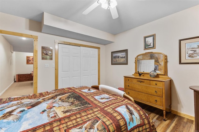 bedroom featuring a closet, light wood-type flooring, baseboards, and a ceiling fan