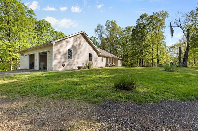 view of home's exterior featuring driveway and a lawn