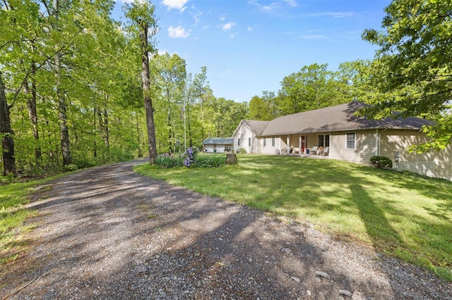 view of front of house featuring covered porch, driveway, and a front yard