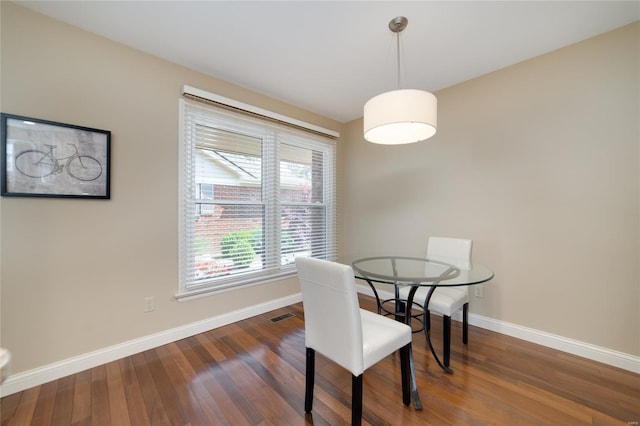 dining room featuring baseboards, wood finished floors, and visible vents