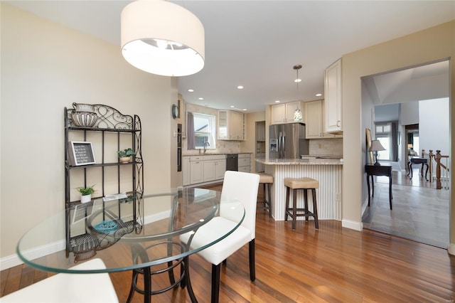 dining space featuring baseboards, recessed lighting, and wood finished floors