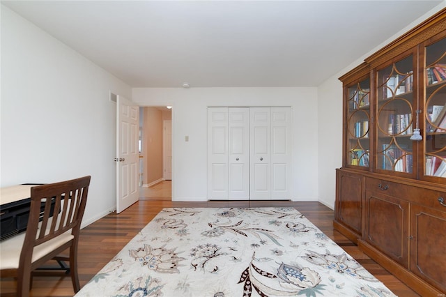 office space featuring baseboards, dark wood-style floors, and visible vents