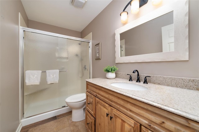 bathroom featuring vanity, tile patterned flooring, toilet, and a shower stall