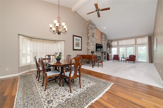 dining room with high vaulted ceiling, a healthy amount of sunlight, beam ceiling, and a fireplace