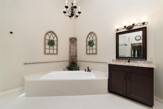 full bathroom with a garden tub, an inviting chandelier, and vanity