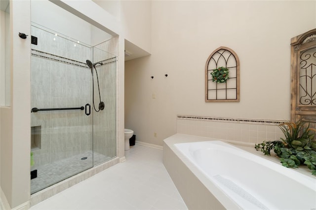 bathroom featuring toilet, baseboards, tile patterned floors, a bath, and a shower stall