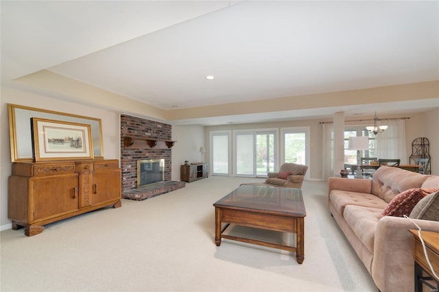 carpeted living area with recessed lighting, baseboards, a notable chandelier, and a fireplace