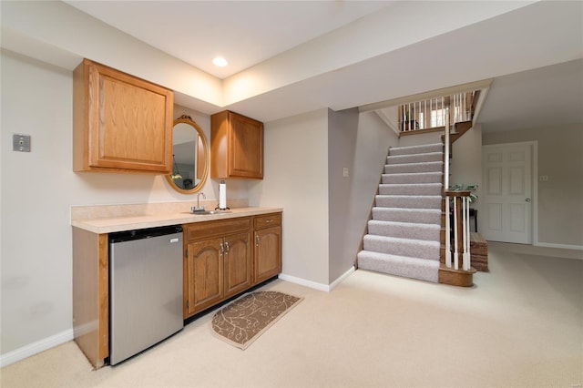 kitchen featuring a sink, baseboards, light carpet, and fridge