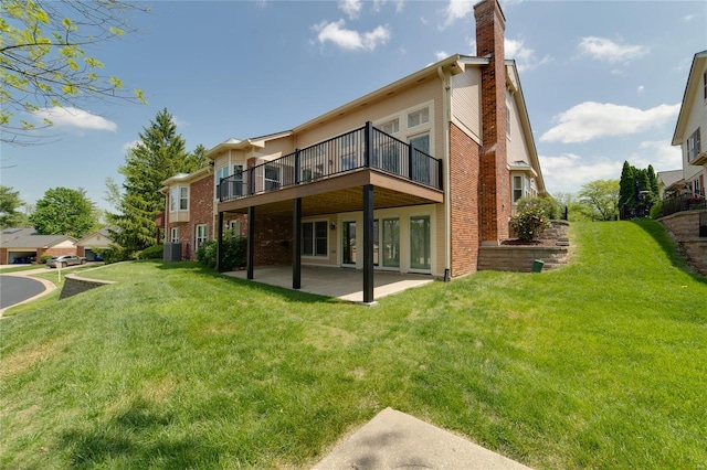 rear view of property featuring a lawn, a patio, a chimney, and central air condition unit