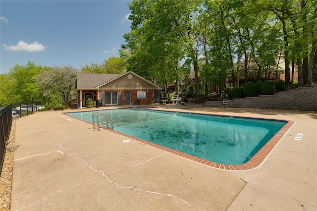 community pool with fence and a patio