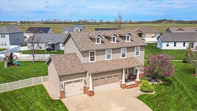 view of front of property with fence, a residential view, an attached garage, a front lawn, and driveway