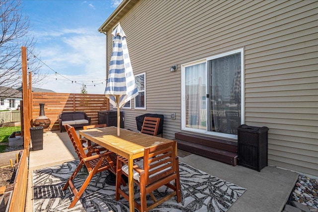 view of patio featuring outdoor dining area and fence