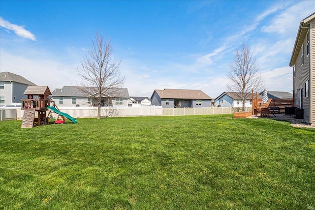 view of yard with a playground, fence, and a residential view