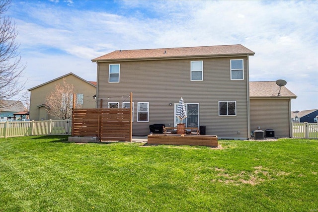 rear view of property with a fenced backyard, a yard, and cooling unit