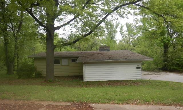 view of side of property with a chimney and a yard