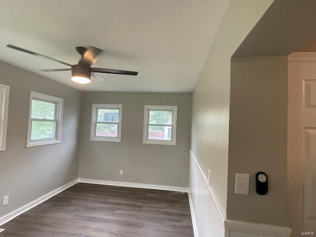 spare room featuring plenty of natural light, a ceiling fan, baseboards, and wood finished floors