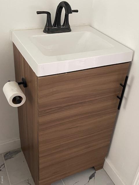 bathroom featuring baseboards, marble finish floor, and vanity