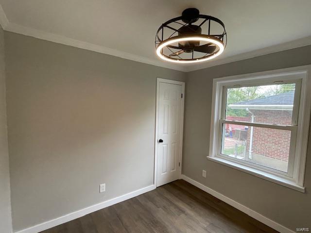 unfurnished dining area with crown molding, baseboards, and dark wood finished floors