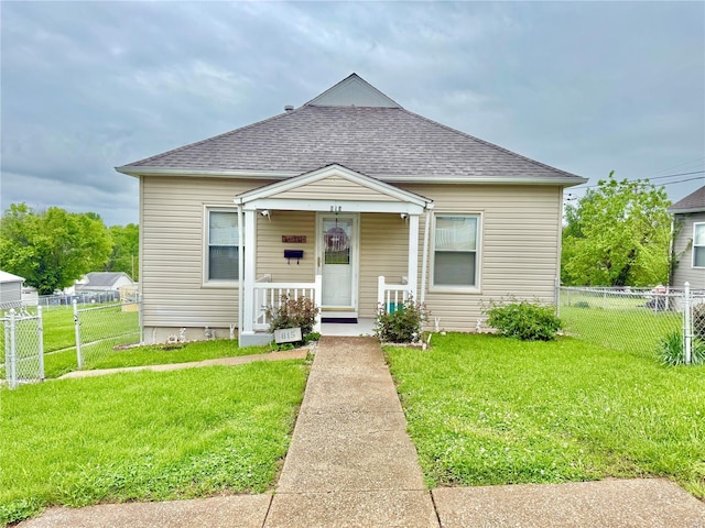bungalow-style house with fence, covered porch, a shingled roof, and a front yard